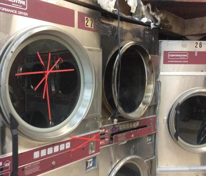 Commerciallaundry dryer showing burn marks after fire