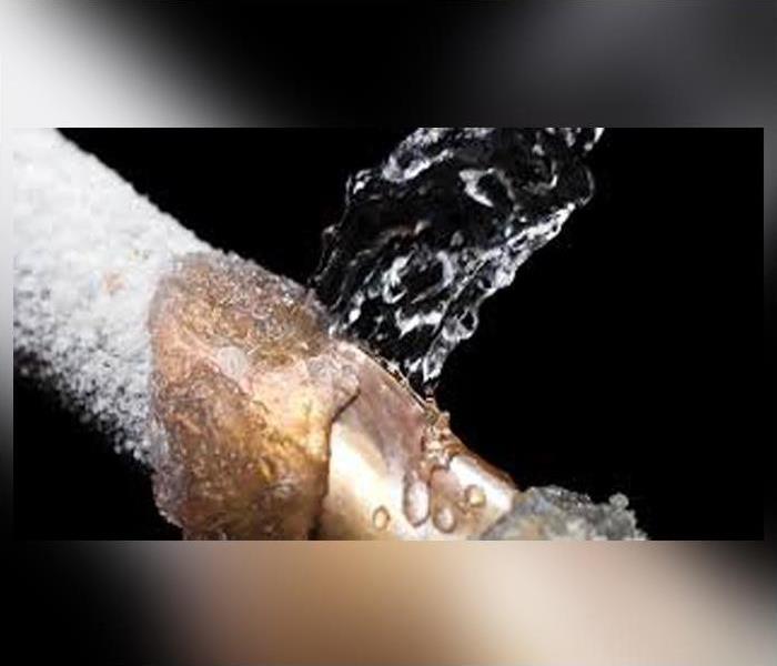 broken pipe covered in ice spraying water